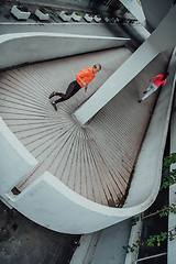 Image showing Two women in sports clothes running in a modern urban environment. The concept of a sporty and healthy lifestyle