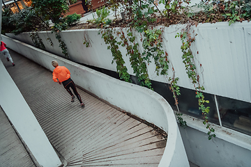 Image showing Two women in sports clothes running in a modern urban environment. The concept of a sporty and healthy lifestyle