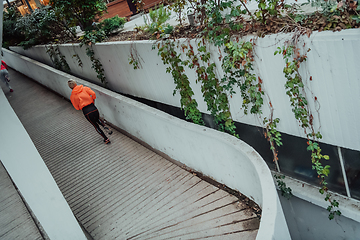 Image showing Two women in sports clothes running in a modern urban environment. The concept of a sporty and healthy lifestyle