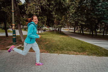 Image showing Women in sports clothes running in a modern urban environment. The concept of a sporty and healthy lifestyle