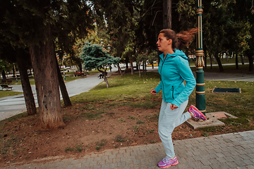 Image showing Women in sports clothes running in a modern urban environment. The concept of a sporty and healthy lifestyle