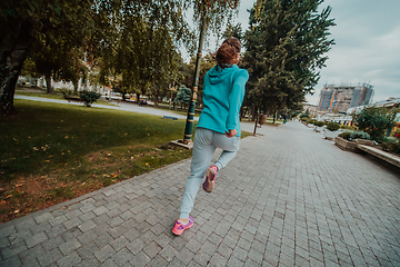 Image showing Women in sports clothes running in a modern urban environment. The concept of a sporty and healthy lifestyle