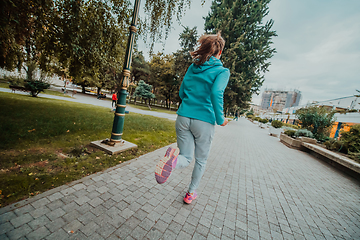 Image showing Women in sports clothes running in a modern urban environment. The concept of a sporty and healthy lifestyle