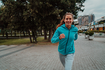 Image showing Women in sports clothes running in a modern urban environment. The concept of a sporty and healthy lifestyle