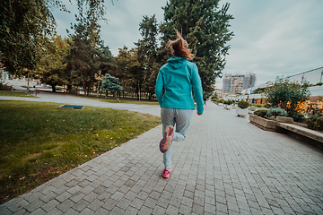 Image showing Women in sports clothes running in a modern urban environment. The concept of a sporty and healthy lifestyle