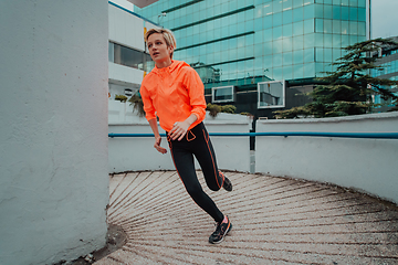 Image showing Women in sports clothes running in a modern urban environment. The concept of a sporty and healthy lifestyle