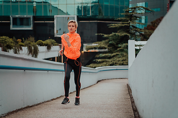 Image showing Women in sports clothes running in a modern urban environment. The concept of a sporty and healthy lifestyle