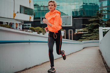 Image showing Women in sports clothes running in a modern urban environment. The concept of a sporty and healthy lifestyle