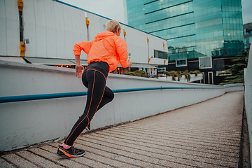 Image showing Women in sports clothes running in a modern urban environment. The concept of a sporty and healthy lifestyle