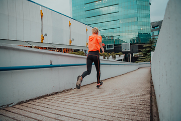 Image showing Women in sports clothes running in a modern urban environment. The concept of a sporty and healthy lifestyle