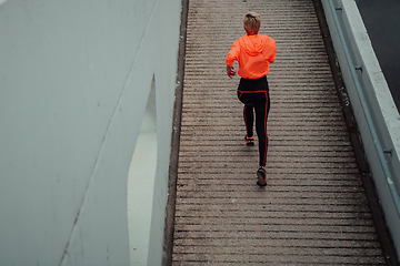 Image showing Top view photo of omen in sports clothes running in a modern urban environment. The concept of a sporty and healthy lifestyle