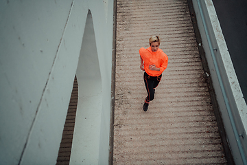 Image showing Top view photo of omen in sports clothes running in a modern urban environment. The concept of a sporty and healthy lifestyle