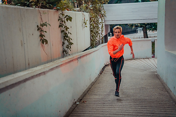 Image showing Women in sports clothes running in a modern urban environment et night time. The concept of a sporty and healthy lifestyle