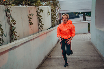 Image showing Women in sports clothes running in a modern urban environment et night time. The concept of a sporty and healthy lifestyle