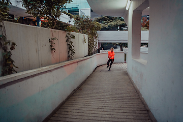 Image showing Women in sports clothes running in a modern urban environment et night time. The concept of a sporty and healthy lifestyle