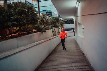 Image showing Women in sports clothes running in a modern urban environment et night time. The concept of a sporty and healthy lifestyle