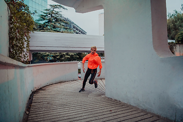 Image showing Women in sports clothes running in a modern urban environment et night time. The concept of a sporty and healthy lifestyle