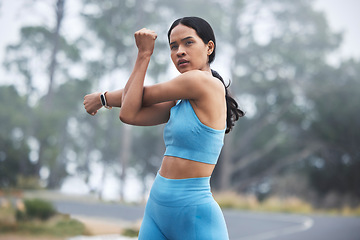 Image showing Arm stretching, woman focus and runner exercise on a outdoor road in the mountains in morning. Workout, running training and wellness of a young female ready for sports and marathon run in mist