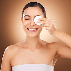 Image showing Skincare, cotton pad and woman eye cleaning of a young person with happiness in a studio. Happy smile and dermatology treatment of a female wiping off cosmetics, wellness and self care facial