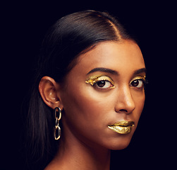 Image showing Indian woman, festive makeup and studio portrait for beauty, wellness and celebration by black background. Model, asian girl or dark aesthetic with gold lipstick, jewellery and cosmetics for face art