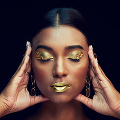 Image showing Woman, face and gold makeup, beauty and glamour with eyeshadow and lipstick on black background. Indian female eyes closed, cosmetics and shimmer with facial, elegant with hands and art in studio