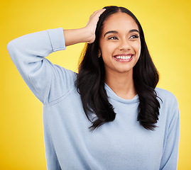 Image showing Thinking, smile and a woman on a yellow background in studio contemplating a happy memory. Idea, vision and mindset with an attractive young female looking thoughtful about the distant future