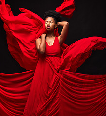 Image showing Black woman, art and fashion, red fabric on dark background with motion and aesthetic movement. Flowing silk, fantasy and artistic beauty, stylish African model in creative designer dress in studio.