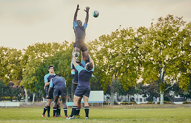 Image showing Sport, men and rugby and jump with team on field, playing game with energy and fitness, ball and action outdoor. Training, exercise and professional match, sports club with male group and active