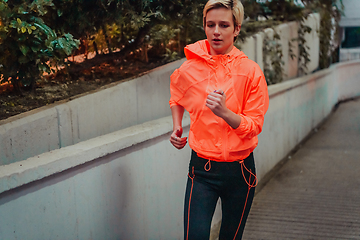 Image showing Women in sports clothes running in a modern urban environment et night time. The concept of a sporty and healthy lifestyle