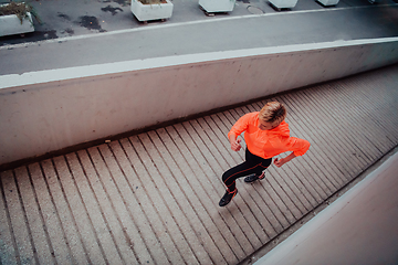 Image showing Women in sports clothes running in a modern urban environment et night time. The concept of a sporty and healthy lifestyle