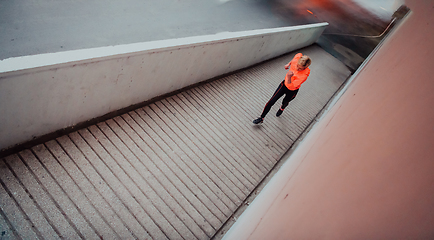 Image showing Women in sports clothes running in a modern urban environment et night time. The concept of a sporty and healthy lifestyle