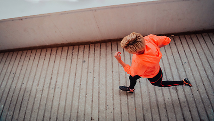 Image showing Women in sports clothes running in a modern urban environment et night time. The concept of a sporty and healthy lifestyle