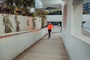 Image showing Women in sports clothes running in a modern urban environment et night time. The concept of a sporty and healthy lifestyle