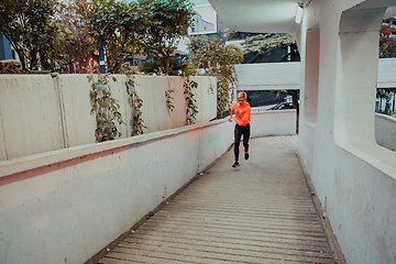 Image showing Women in sports clothes running in a modern urban environment et night time. The concept of a sporty and healthy lifestyle