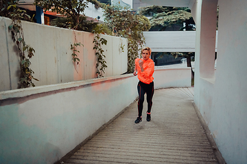 Image showing Women in sports clothes running in a modern urban environment et night time. The concept of a sporty and healthy lifestyle