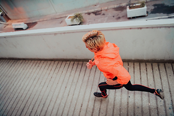 Image showing Women in sports clothes running in a modern urban environment et night time. The concept of a sporty and healthy lifestyle