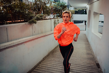 Image showing Women in sports clothes running in a modern urban environment et night time. The concept of a sporty and healthy lifestyle