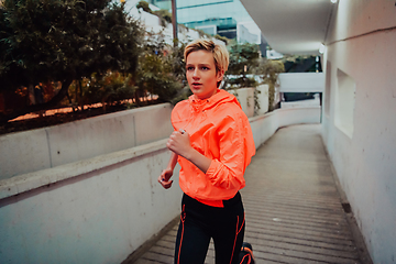 Image showing Women in sports clothes running in a modern urban environment et night time. The concept of a sporty and healthy lifestyle