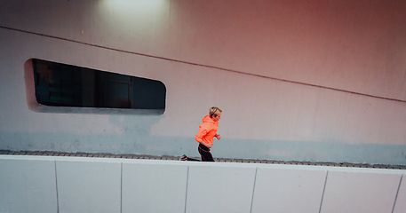 Image showing Women in sports clothes running in a modern urban environment et night time. The concept of a sporty and healthy lifestyle