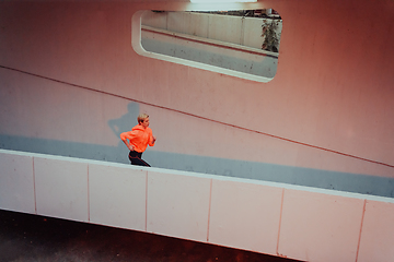 Image showing Women in sports clothes running in a modern urban environment et night time. The concept of a sporty and healthy lifestyle