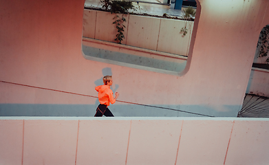 Image showing Women in sports clothes running in a modern urban environment et night time. The concept of a sporty and healthy lifestyle