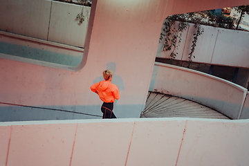 Image showing Women in sports clothes running in a modern urban environment et night time. The concept of a sporty and healthy lifestyle