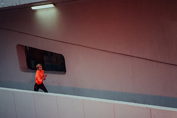 Image showing Women in sports clothes running in a modern urban environment et night time. The concept of a sporty and healthy lifestyle