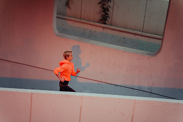 Image showing Women in sports clothes running in a modern urban environment et night time. The concept of a sporty and healthy lifestyle