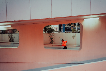 Image showing Women in sports clothes running in a modern urban environment et night time. The concept of a sporty and healthy lifestyle