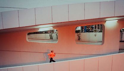 Image showing Women in sports clothes running in a modern urban environment et night time. The concept of a sporty and healthy lifestyle