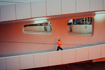 Image showing Women in sports clothes running in a modern urban environment et night time. The concept of a sporty and healthy lifestyle