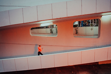 Image showing Women in sports clothes running in a modern urban environment et night time. The concept of a sporty and healthy lifestyle