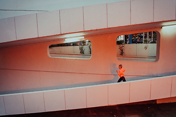 Image showing Women in sports clothes running in a modern urban environment et night time. The concept of a sporty and healthy lifestyle