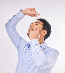 Image showing Man, drop and eyes in studio for health, wellness and treatment for pain, vision or clean by white background. Young asian businessman, eye care and liquid medicine for eyesight, allergy or cleaning